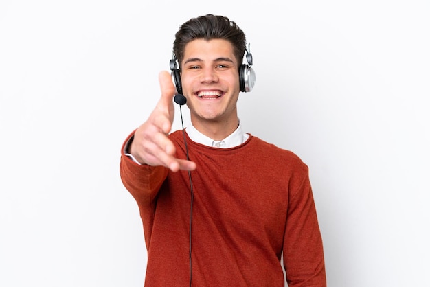 Telemarketer uomo caucasico che lavora con un auricolare isolato su sfondo bianco stringe la mano per chiudere un buon affare