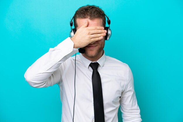 Telemarketer uomo caucasico che lavora con un auricolare isolato su sfondo blu che copre gli occhi con le mani Non voglio vedere qualcosa