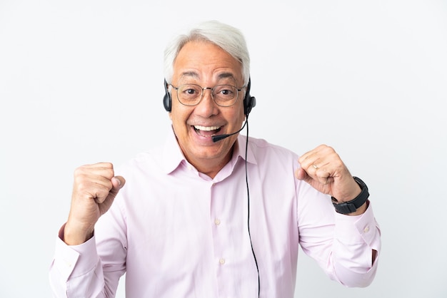 Telemarketer Uomo di mezza età che lavora con un auricolare isolato su sfondo bianco che celebra una vittoria nella posizione del vincitore