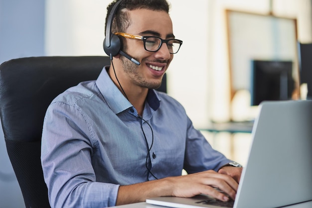 Telemarketing laptop and man consultant in office with smile for positive client feedback on service Headset contact us and male technical support agent with computer for internet crm consultation