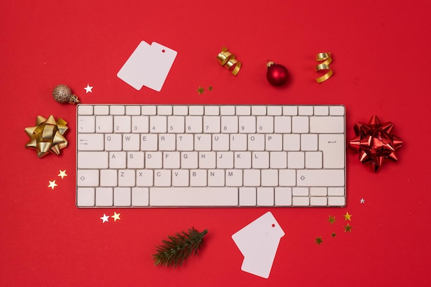Tema delle vacanze di Natale Tastiera del computer bianca Decorazione natalizia rossa e dorata e coriandoli