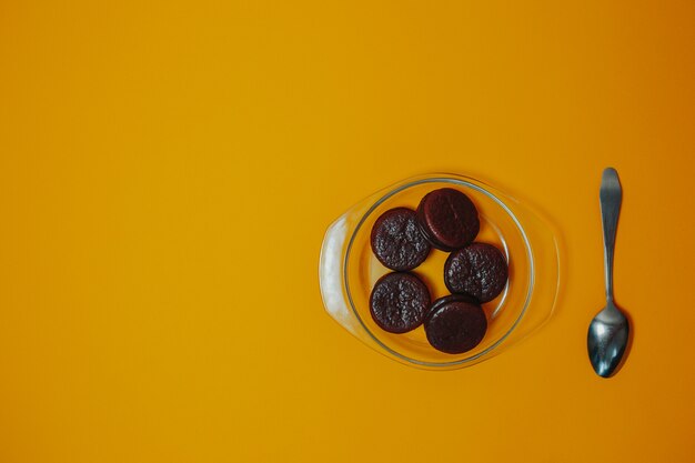 Tema di dieta e perdita di peso. Dolci al cioccolato sul piatto con cucchiaio e copia spazio.