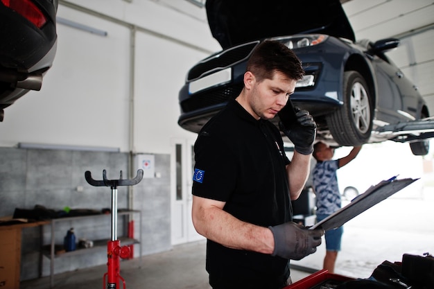 Tema di riparazione e manutenzione auto Meccanico in uniforme che lavora in servizio auto chiama il proprietario per dire i risultati