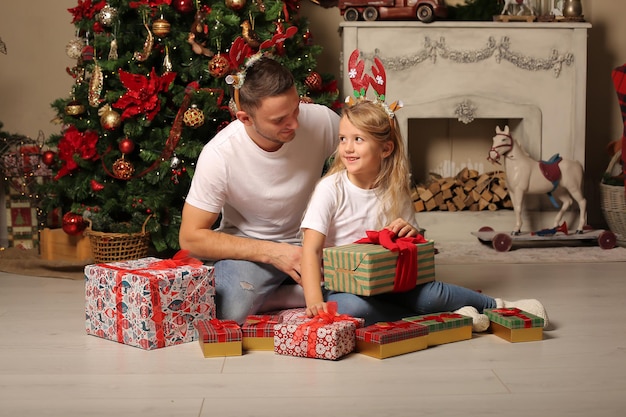 Tema natalizio un padre fa un regalo a sua figlia all'albero di Natale