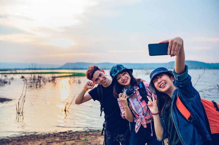 Photo teman-teman bahagia berfoto selfie di tepi danau