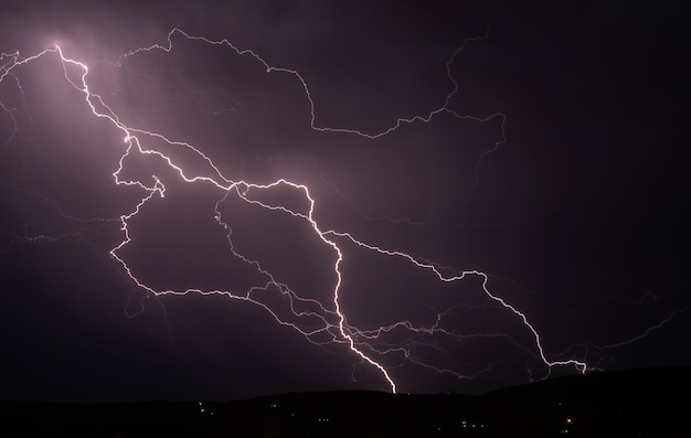 Tempesta di fulmini nel cielo di nuvole scure illuminato dal bagliore del fulmine