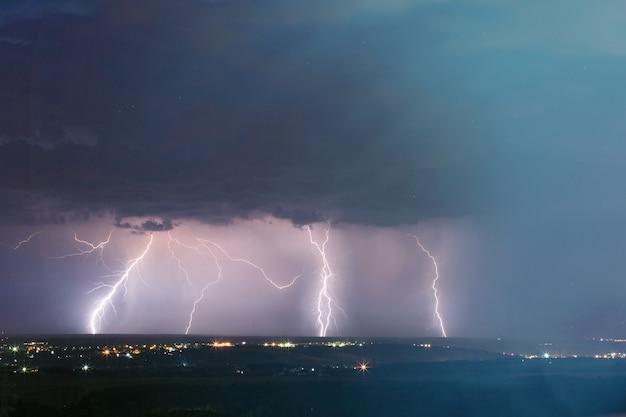 Tempesta di fulmini sulla città. Colpo di fulmine nel cielo blu scuro nella città di notte.