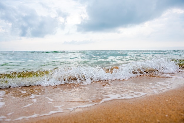 Tempesta su una spiaggia sabbiosa durante il giorno spettacolare scenario oceanico con cielo nuvoloso acqua tempestosa e cras