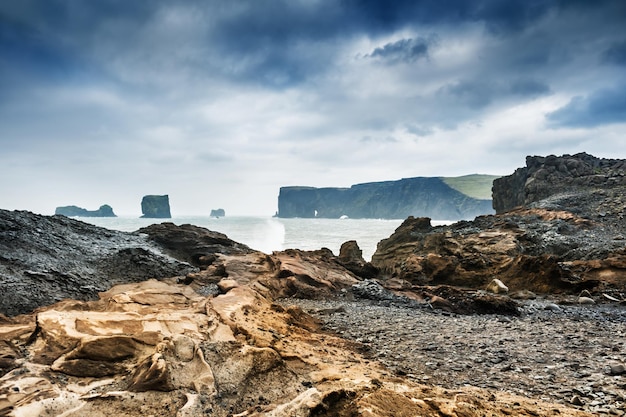 Tempesta sulla costa rocciosa dell'Oceano Atlantico. Dyrholaey, Islanda meridionale.