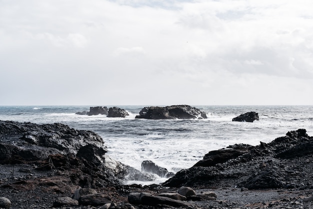 Tempestosa giornata lunatica sulla spiaggia di sabbia nera reynisfjara a sud dell'islanda europa onde enormi su