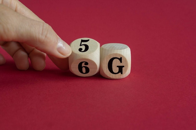 Tempo al simbolo 6G La mano maschile trasforma il cubo di legno e cambia il segno da 5G a 6G
