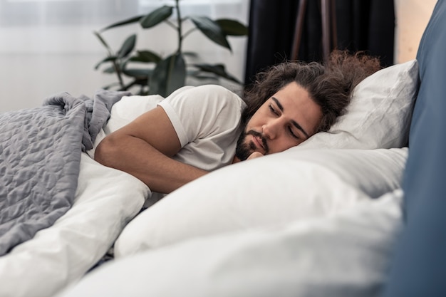 Tempo di dormire. Un bell'uomo barbuto che è nella sua camera da letto mentre dorme di notte