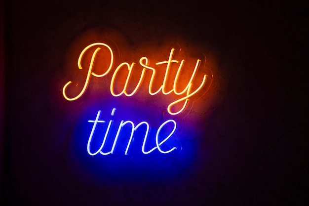 Tempo di festa con scritte al neon luminose su una parete scura