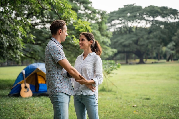 Tempo di picnic e campeggio. Coppia giovane sdraiato sull'erba con la sensazione romantica. Amore e tenerezza, uomo romantico che sorride alla sua ragazza, concetto di stile di vita