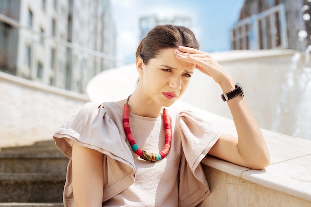 Tempo difficile. Donna infelice depressa che tocca la sua fronte mentre pensa ai suoi problemi