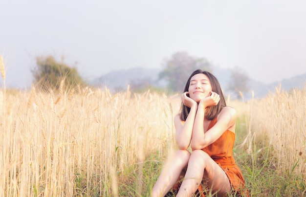 Tempo felice donna asiatica nel campo di orzo