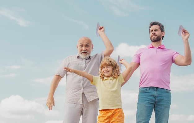 Tempo libero attivo in famiglia con i bambini Ragazzo figlio con padre e nonno con un aeroplano giocattolo gioca sullo sfondo del cielo estivo Concetto di viaggio di viaggio