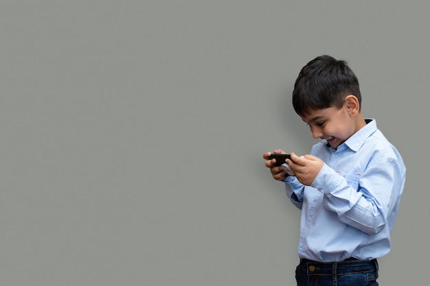 Tempo libero, bambini, tecnologia e concetto di persone - ragazzo sorridente con smartphone o gioco a casa copia spazio