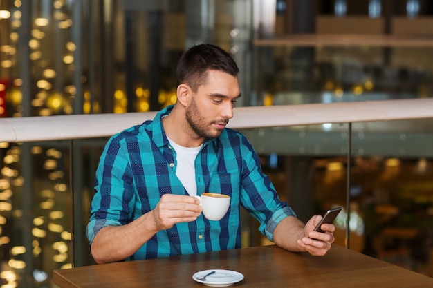 tempo libero, tecnologia, stile di vita e concetto di persone - uomo con smartphone e caffè al ristorante