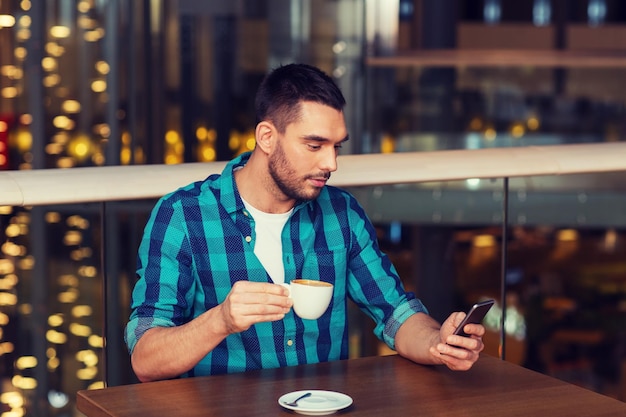 tempo libero, tecnologia, stile di vita e concetto di persone - uomo con smartphone e caffè al ristorante
