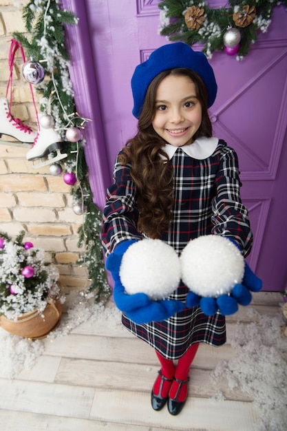 Tempo per condividere. bambino parigino sorridente in berretto e guanti. attività invernale. shopping natalizio. piccola ragazza francese. palla di Natale decorativa per bambini alla moda. decorazioni per la casa e l'albero di Natale. Buon anno.