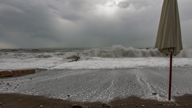 Tempo tempestoso e una barriera costiera della struttura in cemento con l'oceano al di là e le isole sullo sfondo