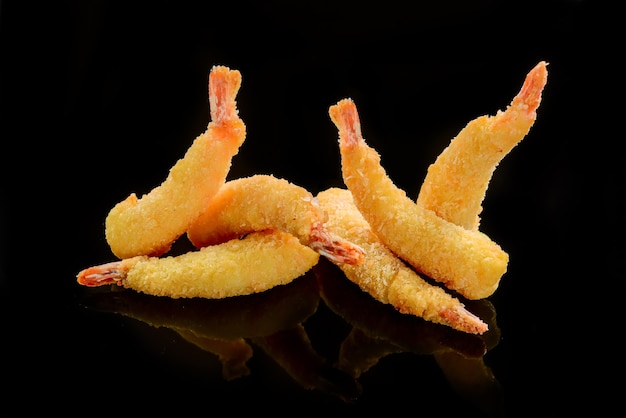 Tempura di gamberi fritti con salsa di peperoncino dolce su una tavola di pietra nera