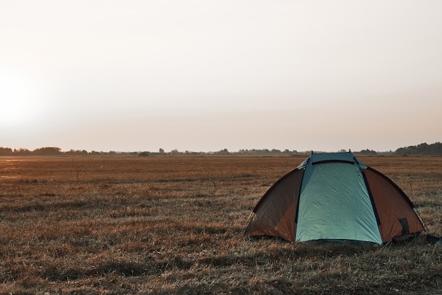 Tenda in campo, alba, autunno.