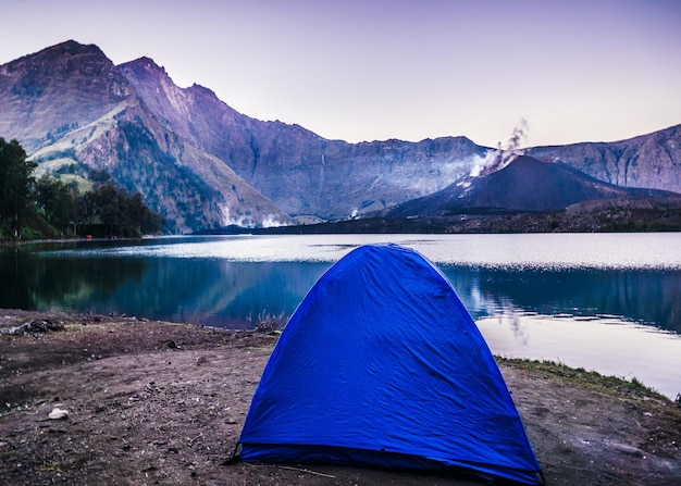Tenda sulla riva del lago dalle montagne contro il cielo