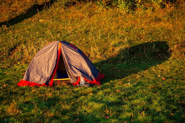 Tenda vicino alla riva del lago al bellissimo tramonto (alba)