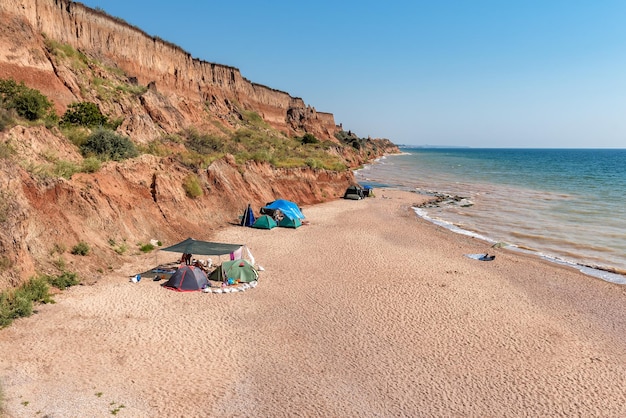 Tende sulla spiaggia sotto la scogliera di sabbia