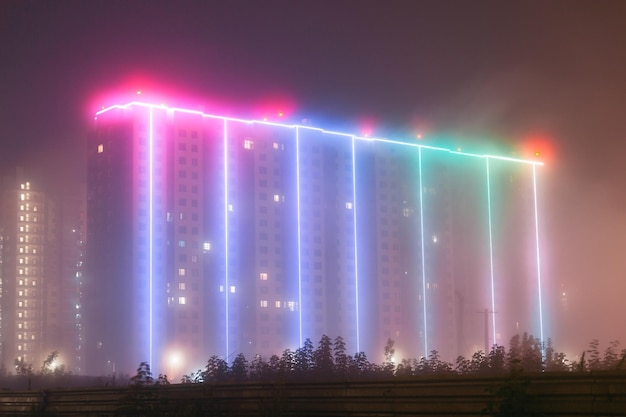 Tenement house con illuminazione in caso di nebbia Luci al neon nella nebbia