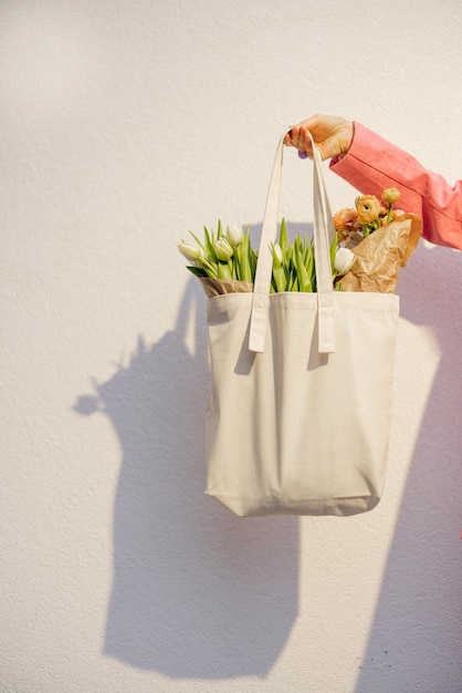 Tenendo borsa tote con fiori