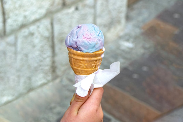 Tenendo cono di cialda fresca con gelato al lampone