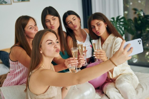 Tenendo i bicchieri con un drink Gruppo di donne felici che è a una festa di addio al nubilato