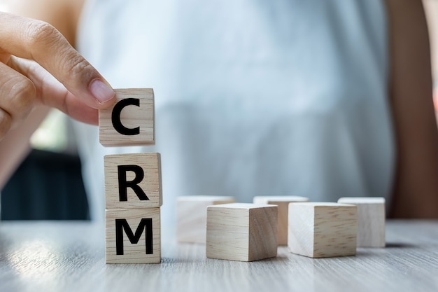 tenendo il cubo di legno con il testo CRM