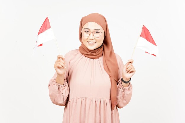 Tenendo la bandiera dell'Indonesia della bella donna asiatica che indossa l'hijab isolato su sfondo bianco