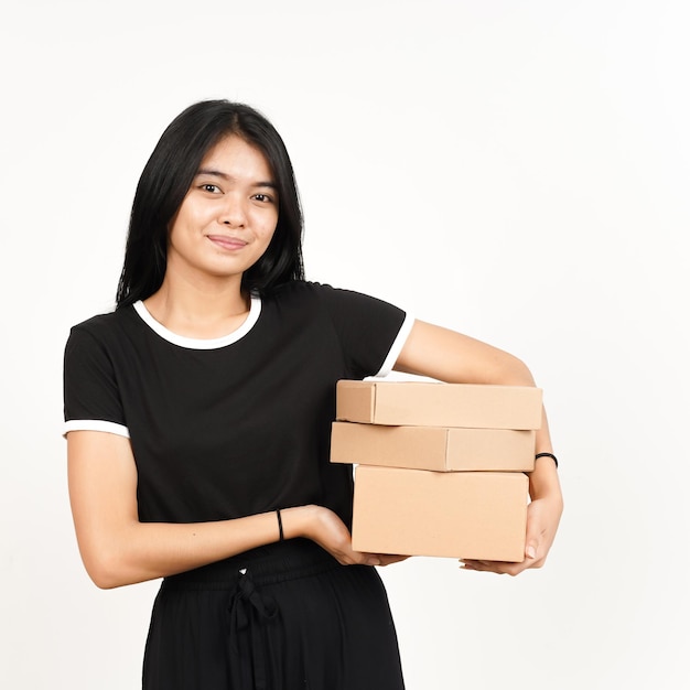 Tenendo la scatola del pacchetto o una scatola di cartone di bella donna asiatica isolata su sfondo bianco