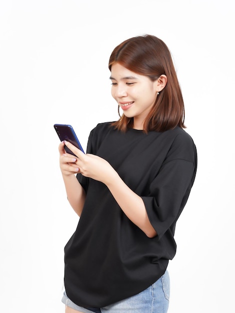Tenendo o utilizzando smartphone e sorriso di bella donna asiatica isolata su sfondo bianco