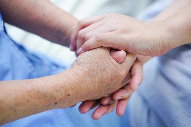 Tenendo per mano il paziente anziano o anziano anziano della signora anziana con amore, cura, incoraggi ed empat