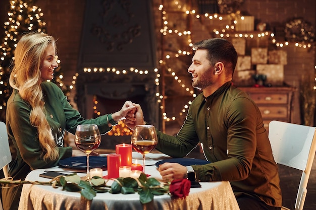 Tenendo per mano La giovane coppia adorabile ha una cena romantica al chiuso insieme