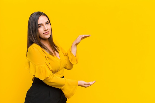 tenendo un oggetto con entrambe le mani sul lato dello spazio di copia, mostrando, offrendo o pubblicizzando un oggetto