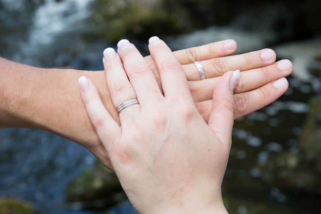 Tenendosi per mano con fedi nuziali