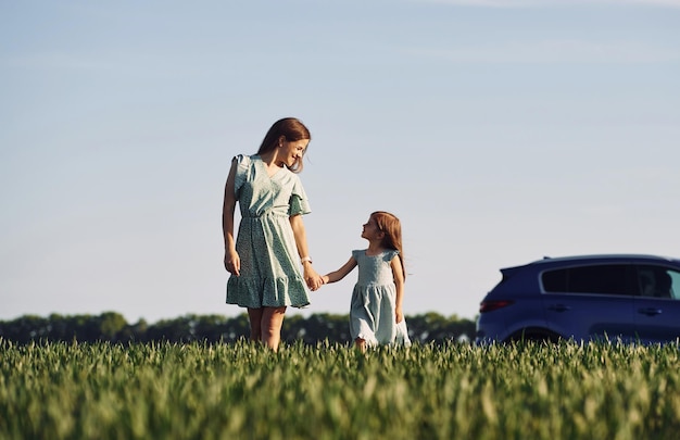 Tenendosi per mano Madre e figlia si divertono all'aperto sul campo in estate