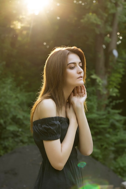 Tenera donna bruna in un raggio di sole