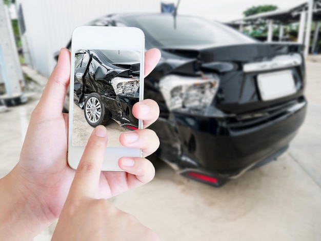 Tenere femmina smartphone mobile fotografare incidente d'auto per l'assicurazione