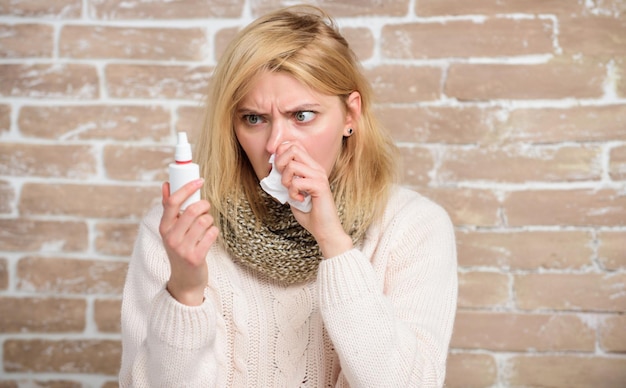 Tenere il farmaco nel naso Soffre di asma o rinite allergica Donna malata con gocce nasali Bella ragazza con naso che cola tenendo gocce nasali Donna carina che allatta raffreddore nasale o allergia