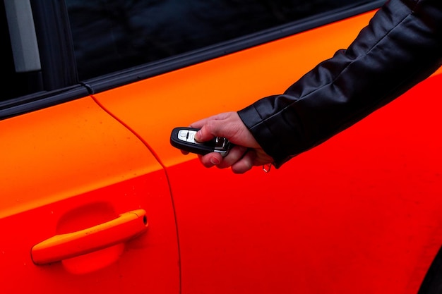 Tenere in mano la chiave dell'auto che apre la portiera dell'auto