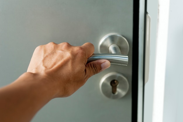 tenere la mano su una manopola per aprire la porta di metallo