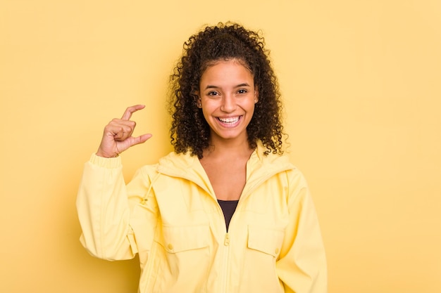 Tenere qualcosa di piccolo con gli indici sorridenti e sicuri di sé